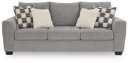 Benchcraft stationary sofa with plush cushions and modern design, featuring neutral fabric upholstery and wide armrests.