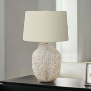 Cream ceramic table lamp with transitional design, featuring a smooth rounded base and a fabric shade for soft ambient lighting.