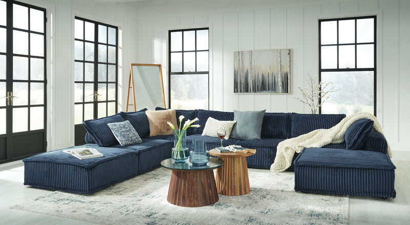 Signature Design by Ashley stationary sectional sofa with plush cushions and modern design, shown in a cozy living room setting.