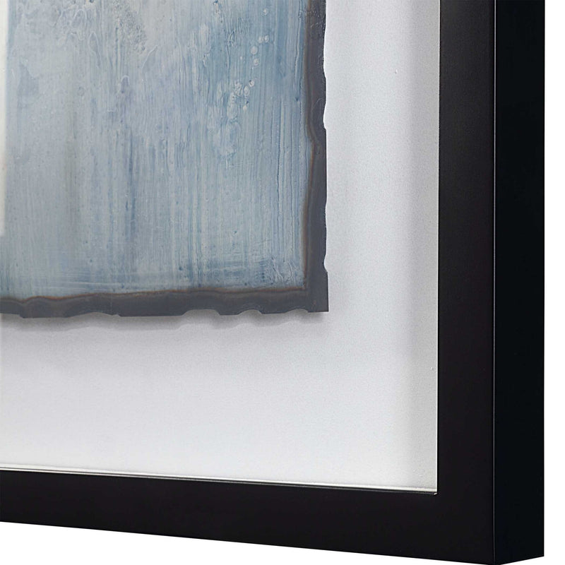 Set of two framed abstract prints featuring blue glimmering agate designs by Uttermost, displayed side by side on a wall.