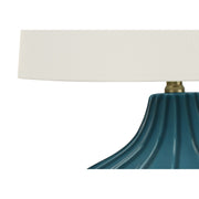Blue ceramic table lamp with a transitional design by 8th Street, featuring a stylish and functional lighting fixture.