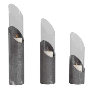 Set of three Uttermost Karter iron and glass candleholders in pearl silver and dark gray with elegant cylindrical design.