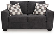 Loreo stationary loveseat by Benchcraft® with plush fabric and cushioned armrests, perfect for cozy living room seating.