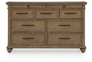 Signature Design by Ashley Karallin dresser with multiple drawers in warm wood finish, showcasing modern bedroom storage furniture.