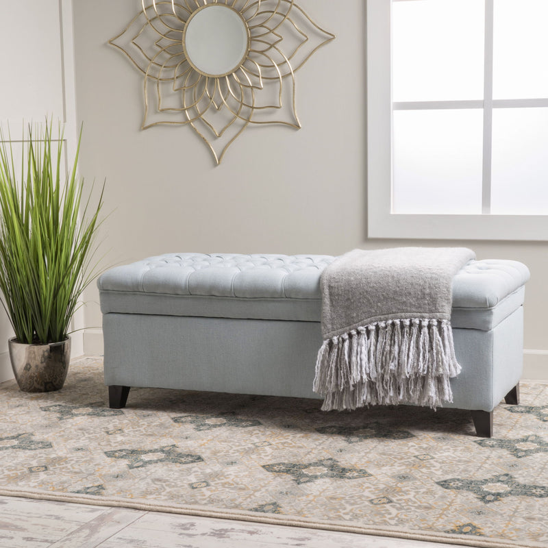 Noble House Juliana storage ottoman with birch wood legs, cushioned top, and spacious interior for versatile home storage.
