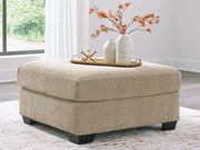 Signature Design by Ashley® SimpleJoy oversized accent ottoman in neutral fabric with plush cushioning and wooden block feet.