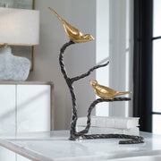 Black and gold Birds On A Limb sculpture by Uttermost, featuring detailed bird figurines perched on a textured branch.