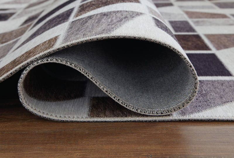 Signature Design by Ashley Jettner area rug featuring a modern geometric pattern in neutral tones.