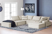 Signature Design by Ashley stationary sectional sofa with plush cushions and neutral fabric in a modern living room setting.