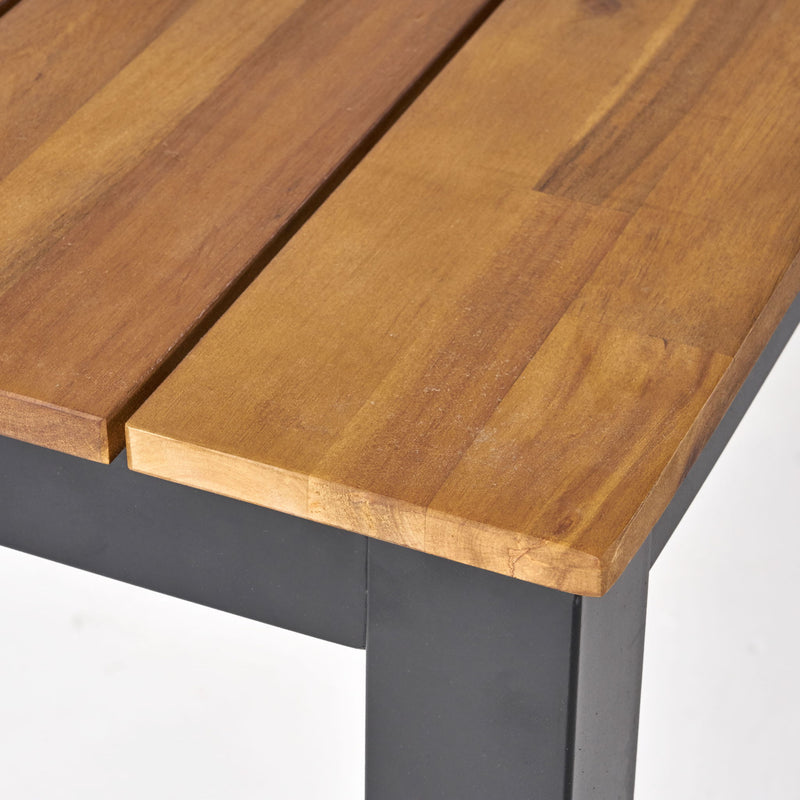 Rectangular outdoor dining table with black tabletop and iron legs, ideal for patio or garden dining, by Noble House.