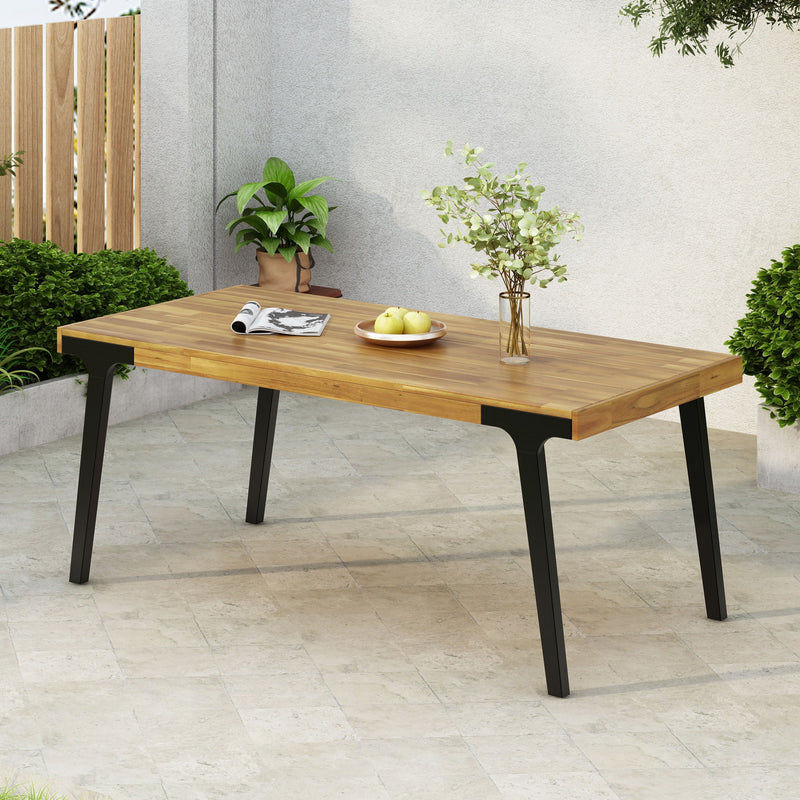 Noble House Acacia wood patio dining table, 69-inch rectangular outdoor table with teak finish and black accents for outdoor dining.