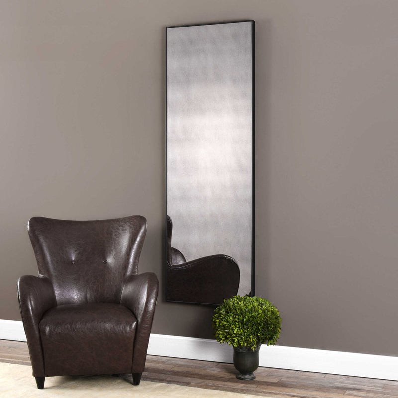 Black oversized antiqued wall mirror by Uttermost, featuring a vintage-inspired frame with a distressed finish.