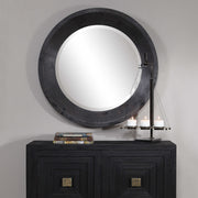 Round black industrial wall mirror by Uttermost with a metal frame, showcasing a modern, sleek design for stylish interior decor.
