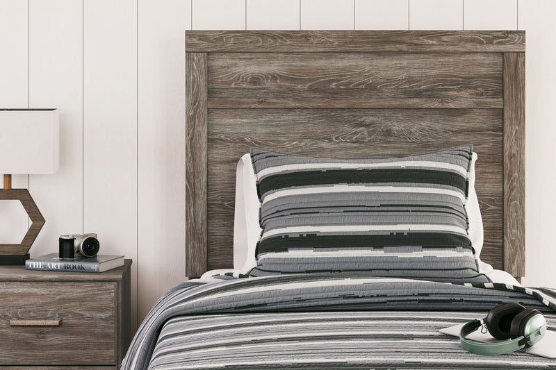 Signature Design by Ashley Ralinksi panel bed with a sleek wood finish and modern headboard design in a cozy bedroom setting.