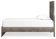 Signature Design by Ashley Ralinksi panel bed with a sleek wooden frame and modern design, shown in a cozy bedroom setting.