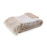 Soft beige Beryl blanket by Classic Home, draped over a cozy chair, showcasing its plush fabric and comfortable design.