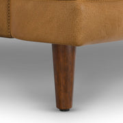 Livingston upholstered stationary sofa by Simpli-Home featuring plush fabric, cushioned backrest, and wooden legs.