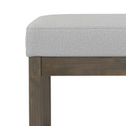 Simpli-Home Milltown upholstered ottoman bench with cushioned top and wooden legs, perfect for living room or bedroom decor.