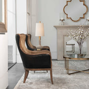 Uttermost Lourosa gold wall mirror with a sleek, round frame hanging on a modern wall.