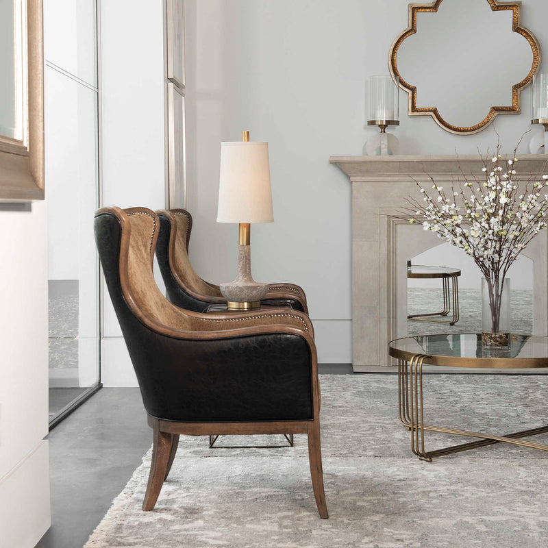 Uttermost Lourosa gold wall mirror with a sleek, round frame hanging on a modern wall.