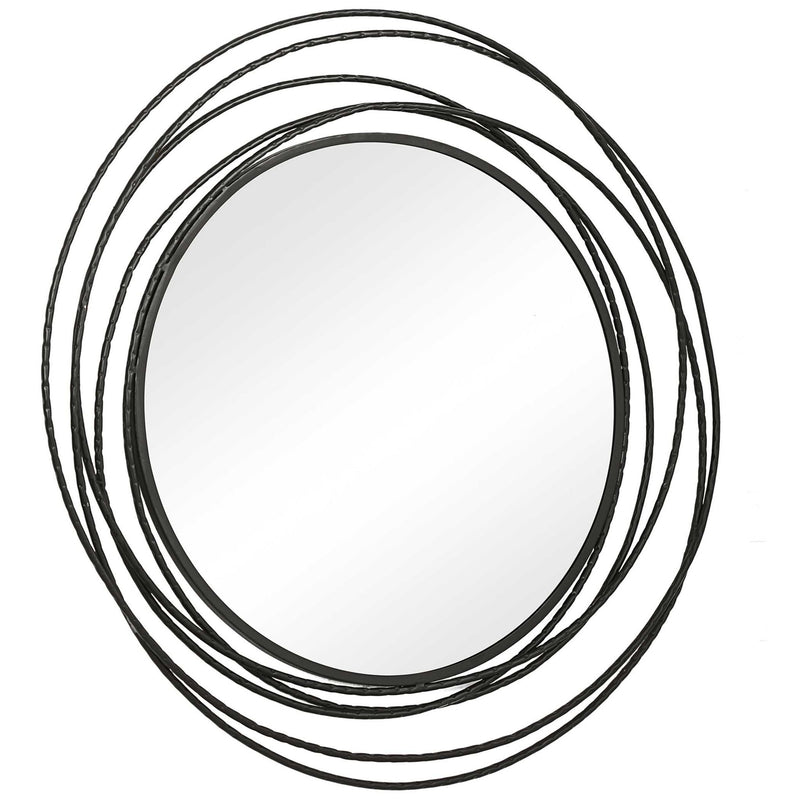 Uttermost Whirlwind round wall mirror with a decorative metal frame, hanging on a wall in a modern interior setting.
