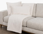 Soft beige Taiga throw blanket by Classic Home, draped over a cozy armchair for a warm, inviting living room setting.