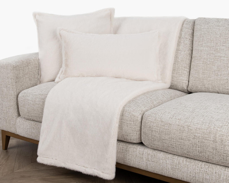 Soft beige Taiga throw blanket by Classic Home, draped over a cozy armchair for a warm, inviting living room setting.