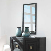 Black industrial wall mirror by Uttermost, featuring a round mirror with a sturdy metal frame and modern industrial design.