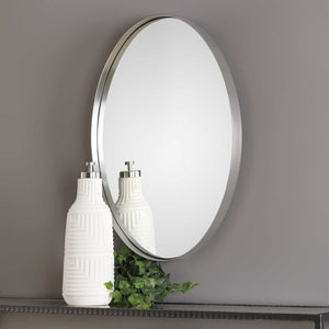Uttermost Pursley oval wall mirror with brushed nickel finish, showcasing a sleek, modern design mounted on a wall.