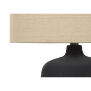 Contemporary black table lamp by 8th Street with a sleek, modern design and cylindrical shade on a minimalist base.