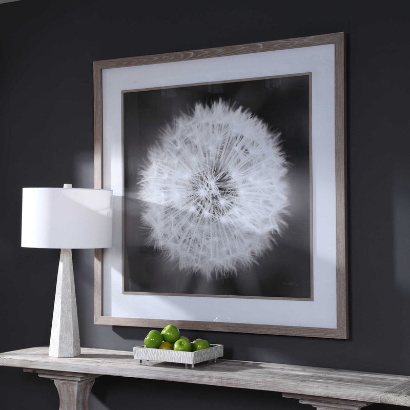 Framed print of dandelion seedhead in black by Uttermost, showcasing delicate seed details on a neutral background.