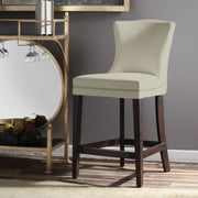 White Dariela counter stool by Uttermost, featuring a sleek design with a cushioned seat and wooden legs, suitable for kitchen counters.