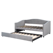 DreamHaus upholstered daybed sofa bed with wood slat frame and pull-out trundle bed in a modern, cozy living space.