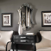 Uttermost Elara wall mirror with antiqued silver finish, framed with elegant decorative details, hanging on a wall.