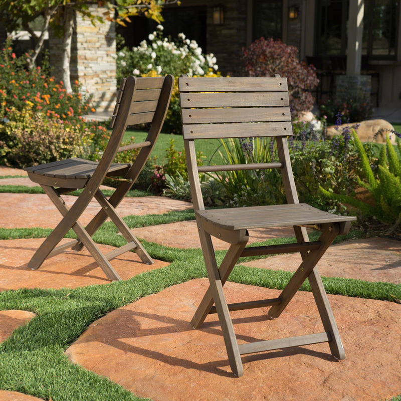 Set of two Noble House outdoor foldable wood dining chairs with slat design, ideal for patio or garden seating.