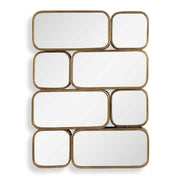 Uttermost Canute modern wall mirror with a sleek, minimalist frame hanging on a wall, reflecting a contemporary interior.