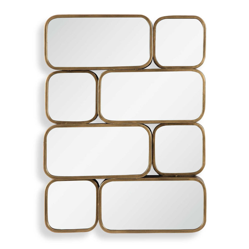 Uttermost Canute modern wall mirror with a sleek, minimalist frame hanging on a wall, reflecting a contemporary interior.