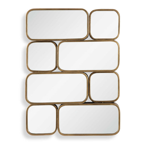 Uttermost Canute modern wall mirror with a sleek, minimalist frame hanging on a wall, reflecting a contemporary interior.