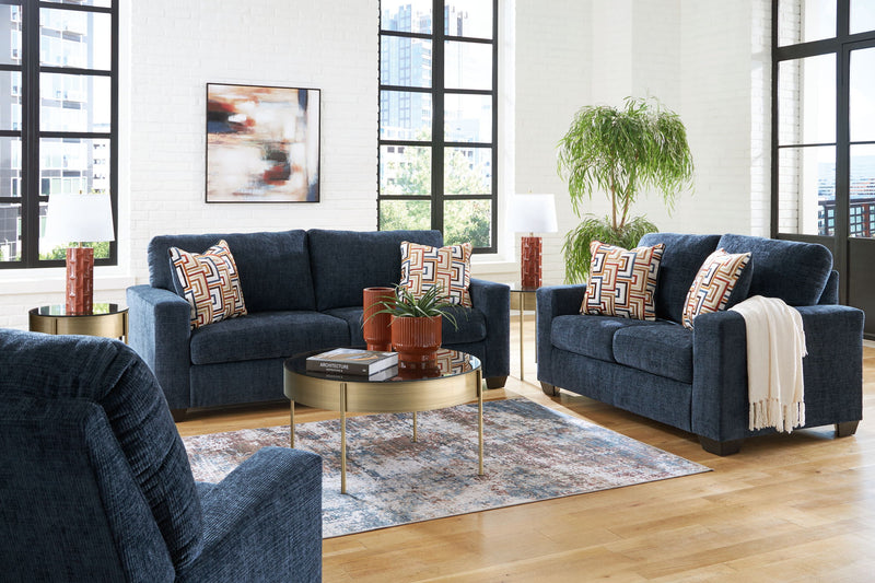 A Signature Design by Ashley Aviemore living room set with beige stationary sofas and loveseats in a modern home interior.