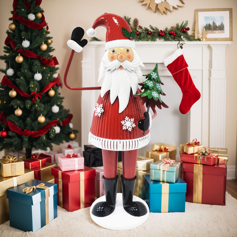 Cheerful Santa Claus Christmas decoration by Noble House holding a tree and waving, festive holiday decor with red accents.