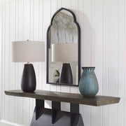 Uttermost Kenitra arched mirror with a sleek, curved frame reflecting modern interior decor.