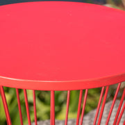 Noble House Lassen modern outdoor side table with a sleek hourglass design, featuring a metal frame and glass top.