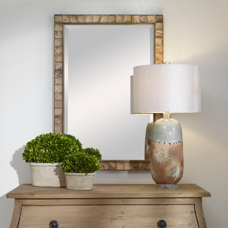 Light brown coconut shell accent mirror by Uttermost featuring a round, textured coconut shell frame.