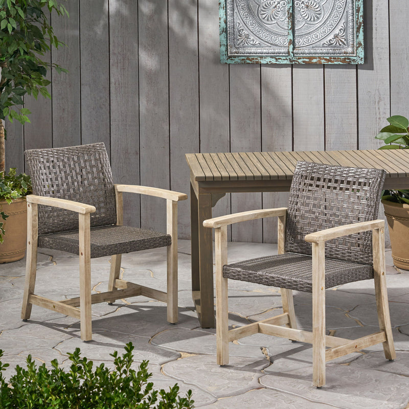Set of two Noble House outdoor dining chairs with acacia wood frames, featuring slatted seats and backrests for garden or patio use.