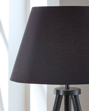 Black Orhan wood floor lamp by Signature Design Ashley® with a sleek, modern wooden base and tall cylindrical shade.