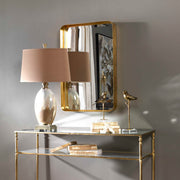 Uttermost Crofton wall mirror with antique gold finish, featuring a round shape and elegant decorative frame.