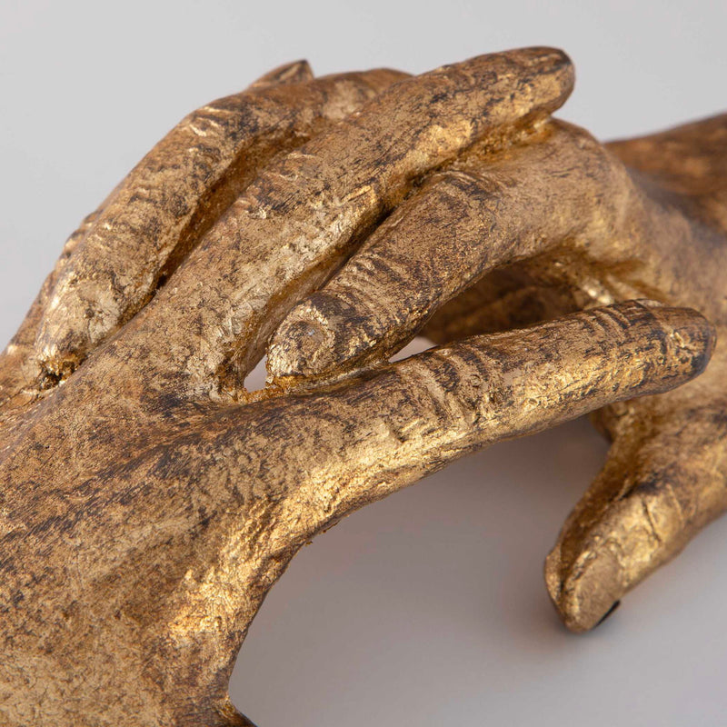 Gold "Hold My Hand" sculpture by Uttermost, a detailed figurine depicting two hands holding each other.