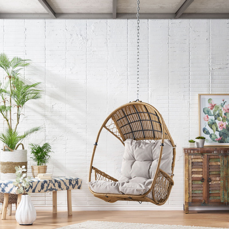 Light brown wicker hanging chair with beige cushion and 8-foot chain, ideal for outdoor or indoor relaxation.