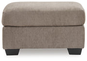 Benchcraft® upholstered Ottoman with a plush fabric finish, featuring a sturdy wooden frame and modern design.