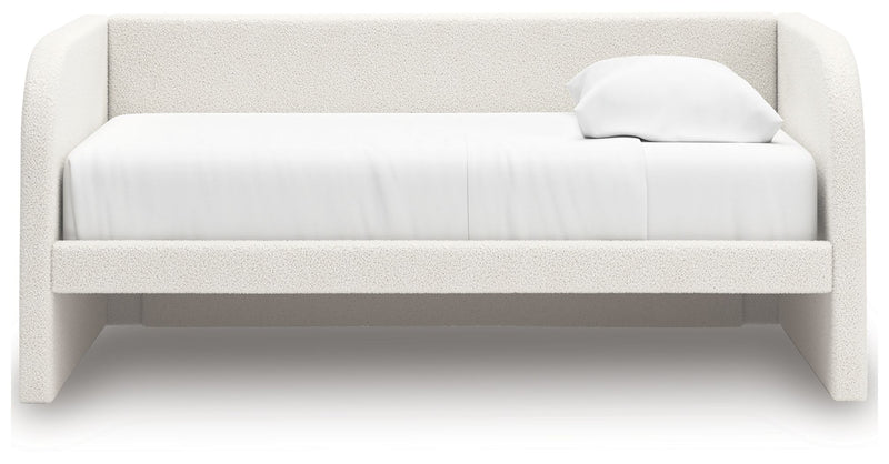 Upholstered Signature Design by Ashley Arloster daybed with plush cushions and wooden frame, ideal for guest or relaxation space.